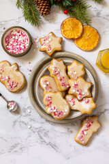 Christmas baking. Homemade gingerbread cookies with glaze on a marble countertop. Top view flat lay. Copy space.