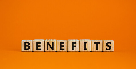 Benefits symbol. Concept word 'benefits' on wooden cubes on a beautiful orange background. Business and benefits concept. Copy space.