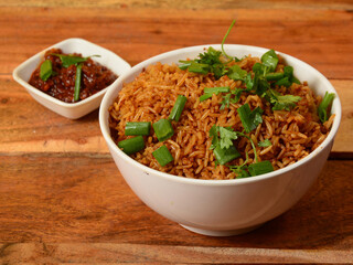 Tasty veg schezwan fried rice served in bowl over a rustic wooden background, Indian cuisine, selective focus