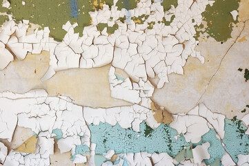 Cracked wall with flaking green paint
