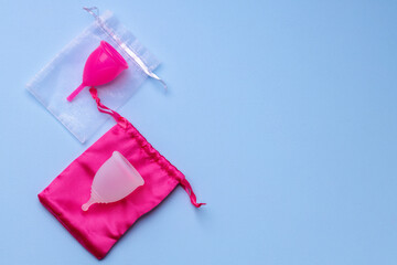 Two menstrual cups on blue background top view