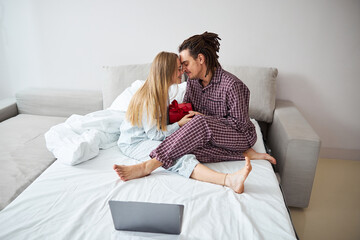 Beautiful young couple touching foreheads in bedroom