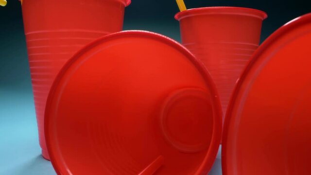 extremely close-up, detailed. red plastic cups cups with cocktail straws on blue background