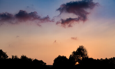 Dramatic orange sunset with clouds in the sky.