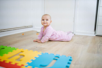 Fototapeta premium Adorable baby lying face down on the wooden floor