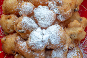 Pile of delicious 'oliebollen' : (deep-fried raisin buns) with powdered sugar: a Dutch traditional delicacy on New years eve.