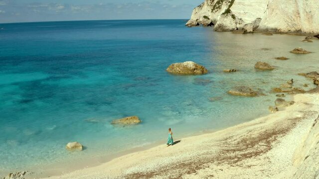 Woman Walking in Solitude on Secluded Erimitis Bay Beach in Paxos, Greece