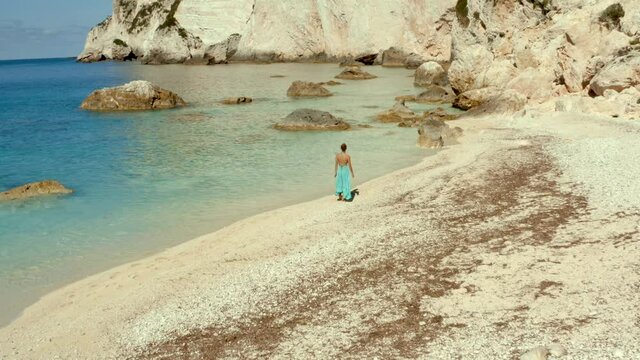 Solitude Concept - Woman Escaping the World on Beautiful Beach in Greece