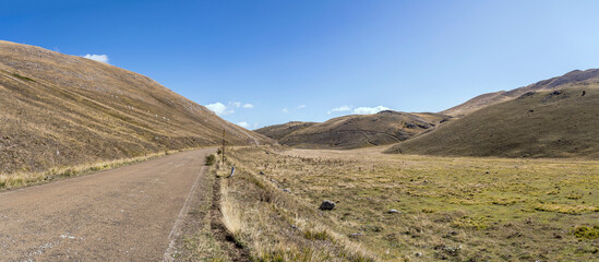 road in mild green slopes at Campo Imperatore upland, Abruzzo, Italy