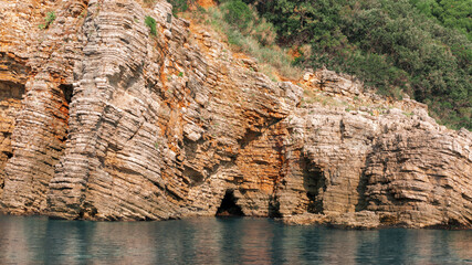 Close up Sea cliff, Layered rocks and stones with turquoise blue sea water