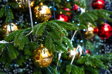 Winter christmas background with fir branches and Christmas balls. Decorated Christmas tree on blurred background.