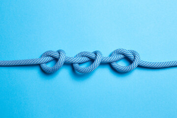 Three knots on a rope on a blue background.