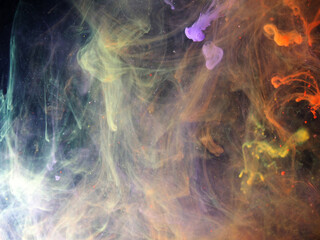 Dissolving paint drops of different colors in water. Red, blue, green, black, purple paint stains in the water.