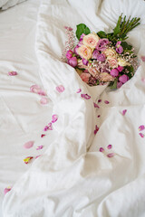 there is a bouquet of flowers on the bed