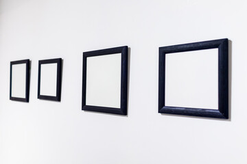 Blank photo frames on white wall in the exhibition room