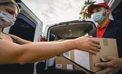 Delivery man wearing face protective mask to avoid corona virus spread - Young express courier...
