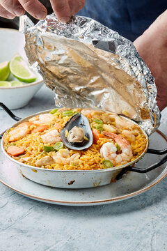 chef cover with aluminium foil to paella traditional spanish dish for cooking