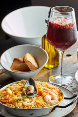 Classic valencian paella from rice with seafood and vegetables - traditional dish of spanish cuisine and sangría