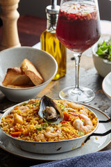 Classic valencian paella from rice with seafood and vegetables - traditional dish of spanish cuisine and sangría