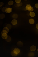 Abstract pattern of golden bokeh garland lights on a dark background