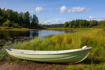 Shabby green boat on the bank of the forest lake, Kainuu region  in Finland