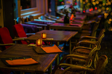 A cozy street cafe with Christmas decorations on the street of the old town Maastricht, Netherlands. Christmas illumination. Bokeh garlands in the background. Christmas, winter, new year concept.