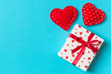 Holiday composition of gift boxes and red textile hearts on colorful background with empty space for your design. Top view of Valentine's Day concept
