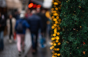 Blur of lighting in night street background. Selective focus. Christmas lights in the dark. Image of blurred background with warm colorful lights. Shopping, winter holidays.