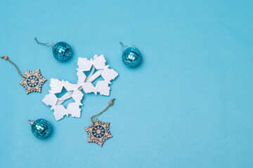 Christmas flat lay. Snowflake glasses, snowflake ornaments and christmas balls on blue background
