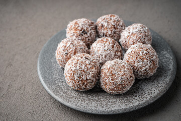 Vegan date sweets on a grey plate on a concrete surface