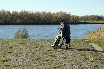 Ein Senior sitzt auf seinem Rollator