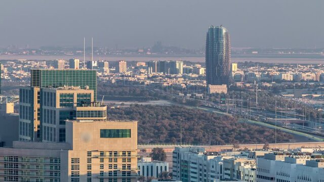 Aerial skyline of Abu Dhabi city centre from above timelapse before sunset with shadows from skyscrapers.
