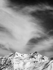 Black and white winter snowy mountains at windy day
