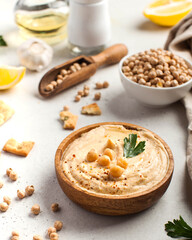 Hummus in a wooden plate with parsley and croutons. Dishes of chickpeas, a vegetarian dish.