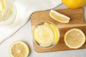 Soda water with lemon slices on light table, flat lay