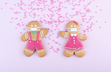 gingerbread men boy and girl in a ginger cookie face mask iced sugar decoration on a pink background