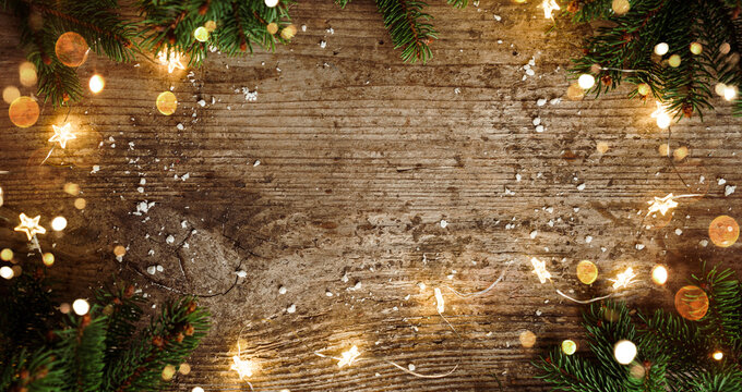 Merry Christmas frame made of Christmas decorations, fir branches, spruce, lights garland, snowflakes on wooden background. Xmas and New Year holiday, bokeh, light. Flat lay, top view, banner