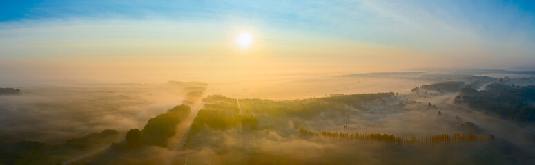 Panoramic aerial view of early morning mist over plain vegetation