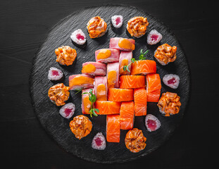 set of sushi roll with salmon, avocado, cream cheese, cucumber, rice, tuna in plate on black background