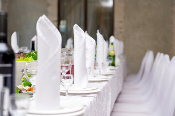 Banquet table with dishes, white napkins