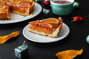Piece of pumpkin pie on a black background. Vegetarian baked goods, dessert.