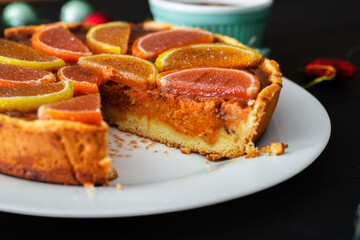Piece of pumpkin pie on a black background. Vegetarian baked goods, dessert.