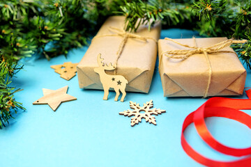 Christmas background with gifts in craft paper and a Christmas tree on a blue background. Christmas...