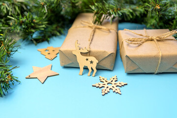 Christmas background with gifts in craft paper and a Christmas tree on a blue background. Christmas...