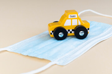 Yellow taxi car on medicine mask . Safety taxi , health protection and pandemic concept .
