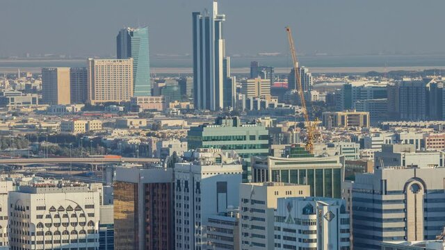 Aerial skyline of Abu Dhabi city centre from above timelapse before sunset with shadows from skyscrapers