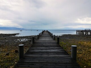 Perspective looking out at an empty pier on Lake Tahoe on a stormy day 