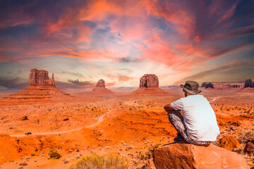 A young man in a white t-shirt in Monument Valley National Park at the visitor center at sunset,...