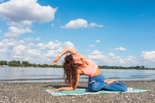 front view of young woman practice yoga stretch near river sunny summer day healthy lifestyle concept