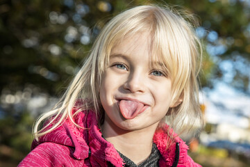 Kleines Mädchen streckt frech Zunge heraus